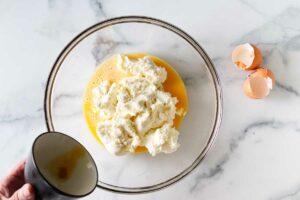 Combining ricotta cheese with eggs and cheese.