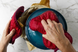 Removing the dutch oven lid to finish cooking the bread.