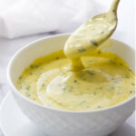 A spoon in a bowl of French Béarnaise blender sauce.