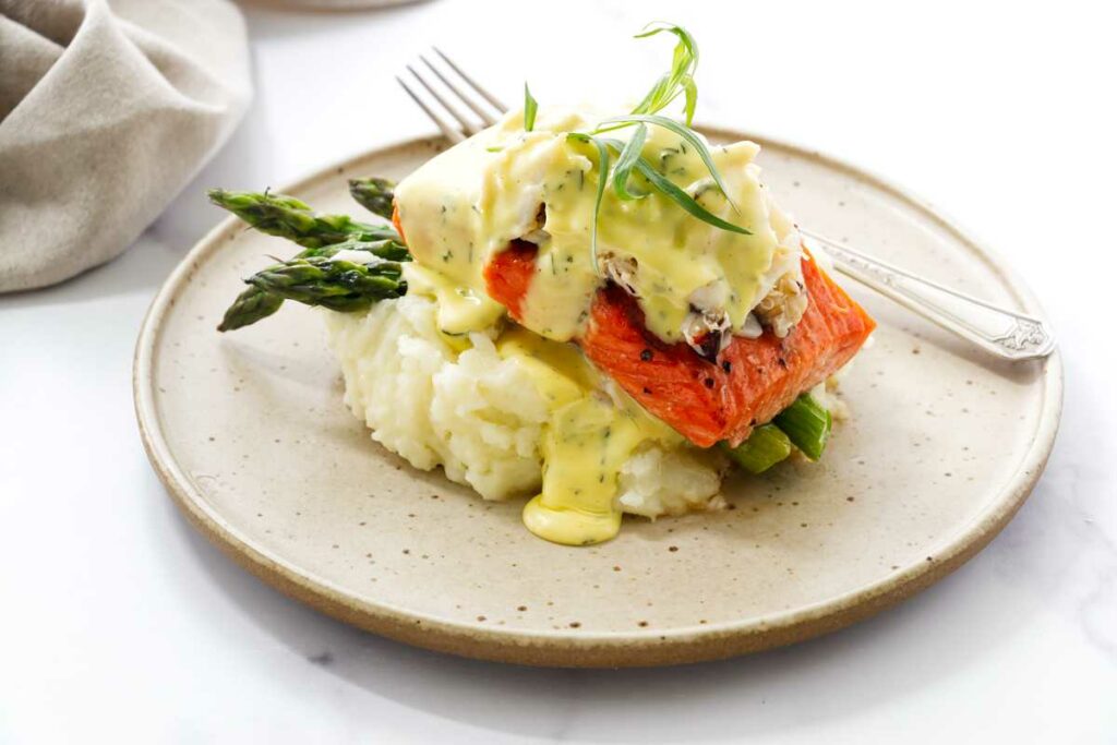 A serving of crab and salmon oscar over mashed potatoes.