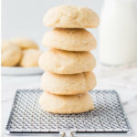A stack of thick and soft sugar cookies on a wire rack.