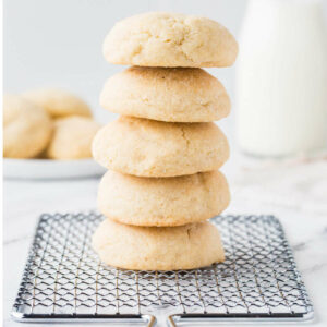 A stack of thick and soft sugar cookies on a wire rack.