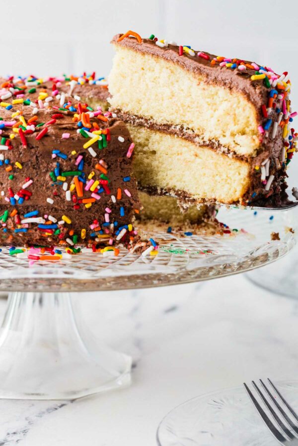 A spatula serving a slice of cake from a cake platter.