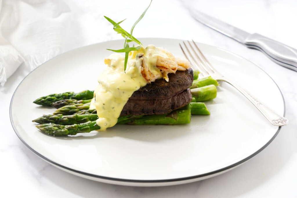 A steak on asparagus topped with crab meat and bearnaise sauce.