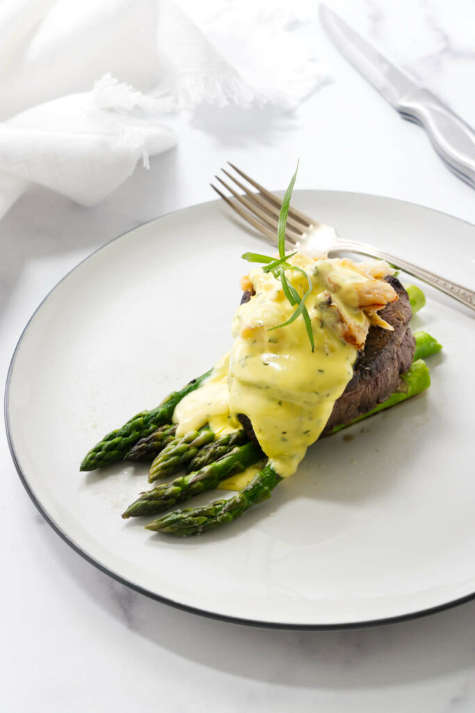 A steak oscar on a plate with a fork.