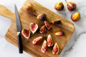Slicing fresh figs on a cutting board.