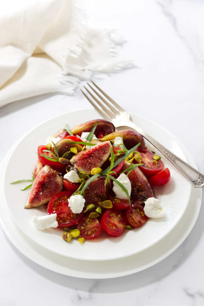 A salad plate filled with tomatoes, figs, and balsamic dressing.