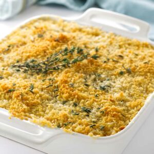 Golden breadcrumb-topped casserole in white dish, garnished with thyme.