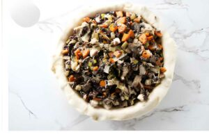 Unbaked pie crust filled with chicken and rice.