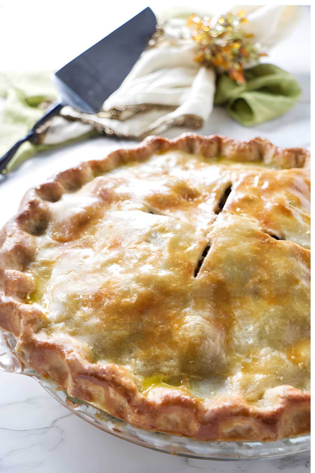 Golden-brown homemade pot pie with flaky crust and vent slits.