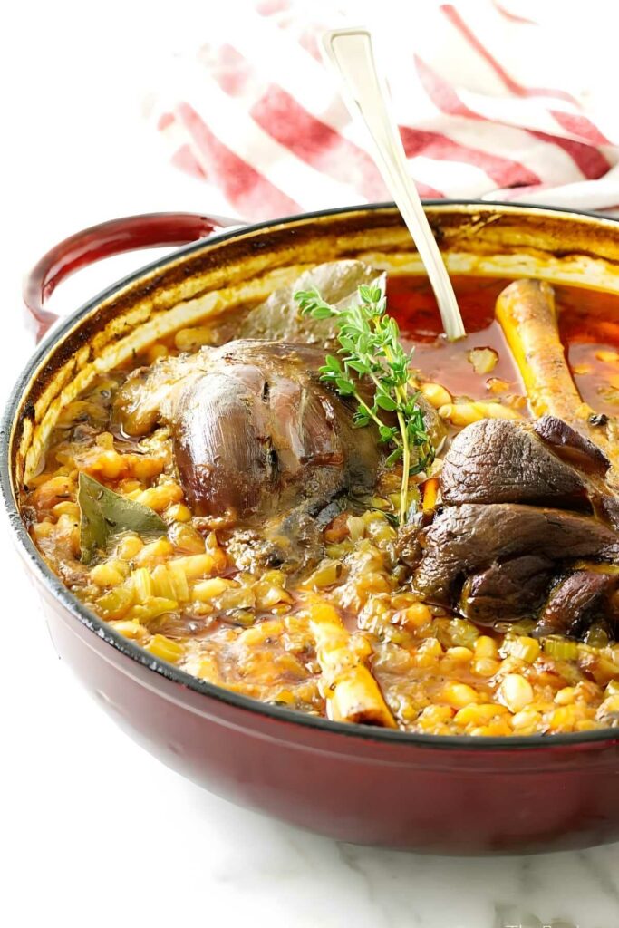 Dutch oven with lamb shank cassoulet and herbs. 