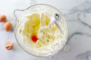 Adding eggs to the creamed butter.
