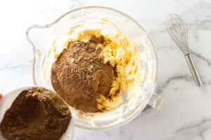 Adding the dry ingredients to the cake batter for mini bundt cakes.