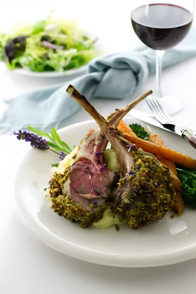 Pistachio crusted rack of lamb on mashed potatoes with carrots and greens.