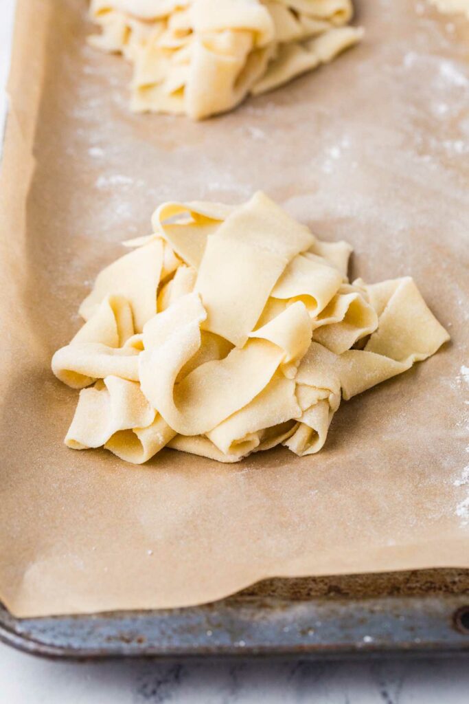 Fresh pasta placed in a pile on a counter.