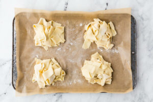 Piles of fresh pasta on a parchment paper.