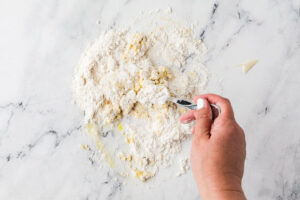 Mixing pasta dough on a counter.