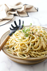 A serving bowl filled with tuna and spaghetti noodles.