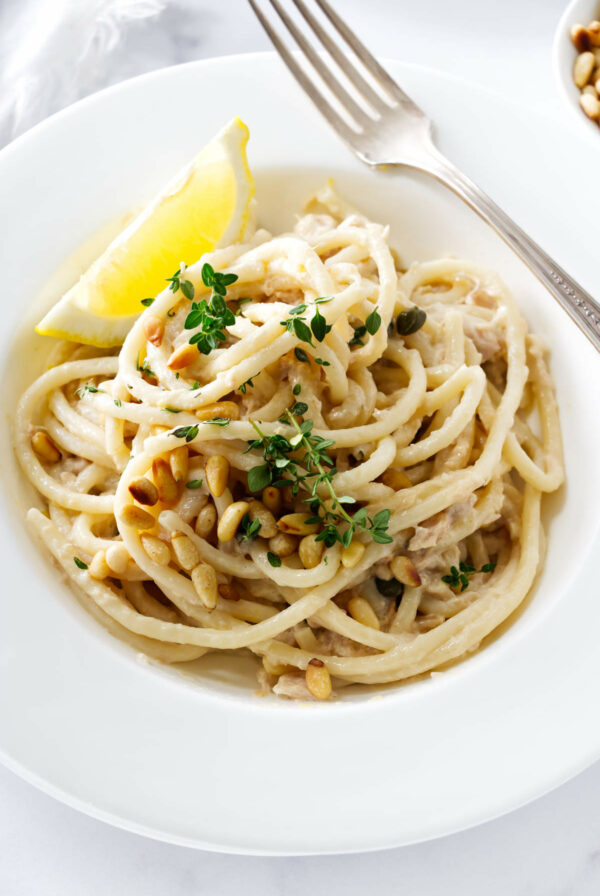 A white pasta bowl filled with tuna pasta.