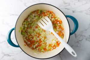 Sauteeing vegetables in a large soup pot.
