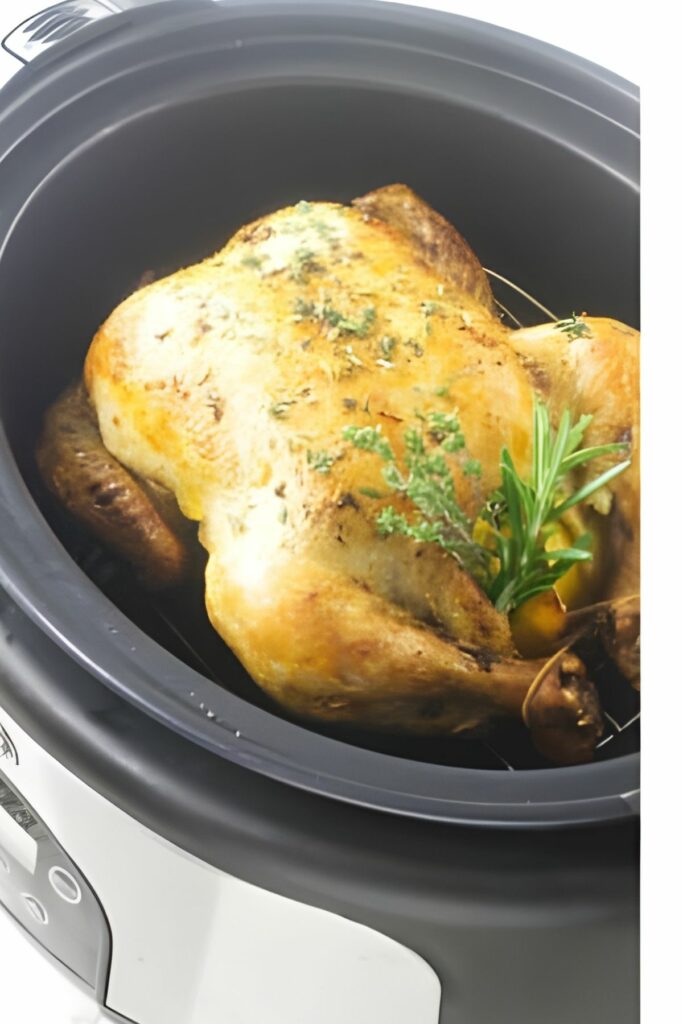 A whole chicken with herbs inside a slow cooker.