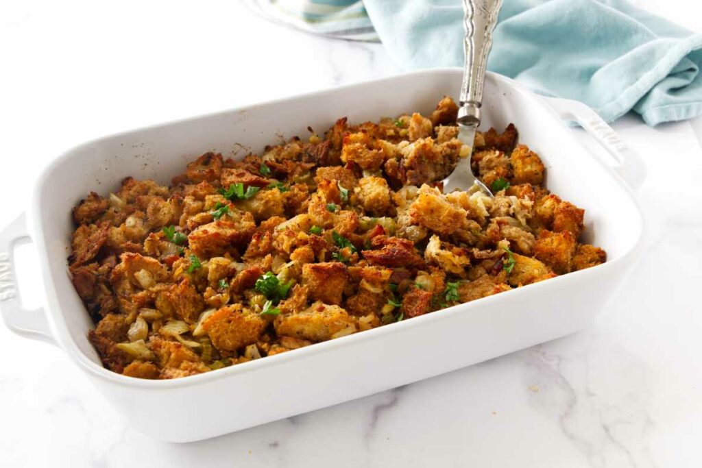 A spoon scooping out some rustic bread and fennel stuffing.