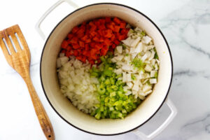 Adding vegetables to the soup pot.