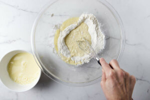 Whisking the wet batter into the flour mixture.