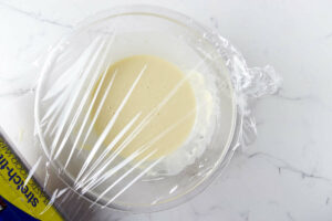 Covering crepe batter in a bowl.