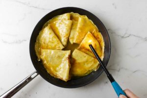 Lighting a match over a skillet with crepes suzette.