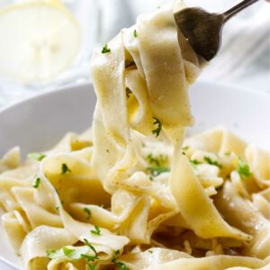 A fork picking up some freshly cooked pasta.