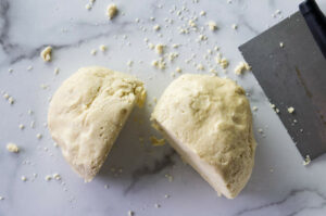 Dividing pie dough into two sections.