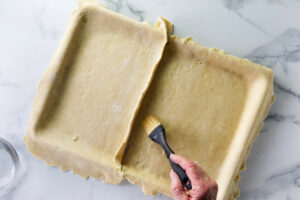 Sealing the edges of the pastry that meet in the center.