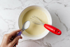Stirring milk into sourdough crepe batter.