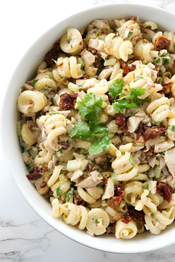 Pasta salad in a bowl with chicken and spicy chipotle sauce.