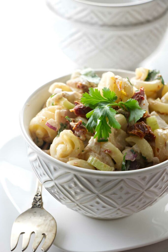 A small dish filled with pasta salad next to a fork.