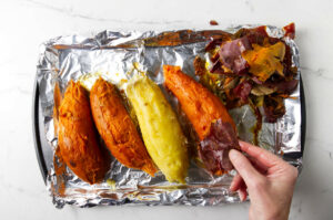 Peeling the skin off of freshly baked sweet potatoes.