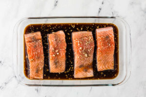 Marinating salmon in teriyaki sauce.