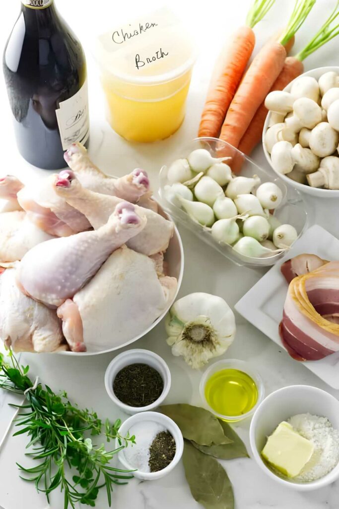 Assorted raw chicken and vegetables with herbs, seasonings, wine, and broth on white.