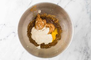 Combining sourdough discard, peanut butter, and eggs to the cookie dough.