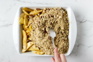 Spreading the crunch topping on the apple filling.