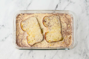 Soaking bread in spiced custard for french toast.