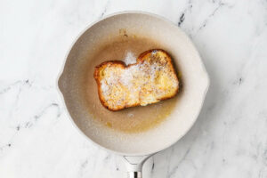 Flipping the bread over to cook the other side of the french toast bread.