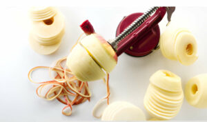 Using an apple peeler and corer to slice apples thinly for the cake.