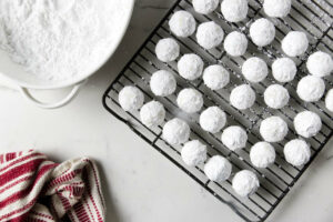 Rolling the cookies in powdered sugar a second time to get covered well.