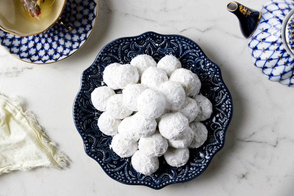 A plate filled with Italian powdered sugar cookies.