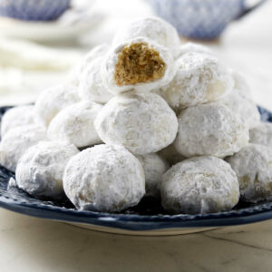 A stack of Italian wedding cookies on a blue plate.