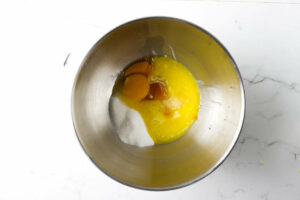 Combining pumpkin puree with eggs, sugar, butter, and milk.