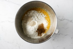 Adding flour to pumpkin puree cinnamon rolls dough.
