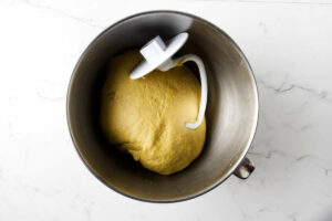 Pumpkin spice dough in a mixing bowl with a kneading attachment.